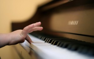 childs hand playing a key