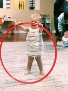 Baby smiling while holding a hula hoop