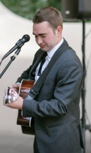 Man in suit playing guitar on stage