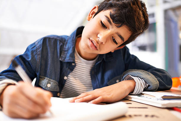 Image Of A Young Boy Focusing on Doing His Homework